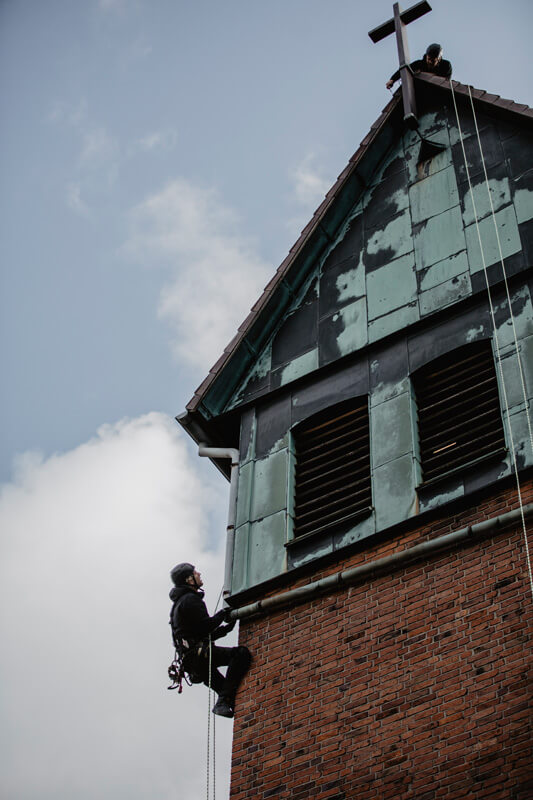 Industriekletterer kontrollieren das Kirchturmdach und die Kirchturmfassade