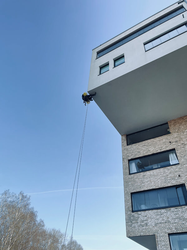 Ein Industriekletterer repariert Spechtloch an WDVS-Fassade