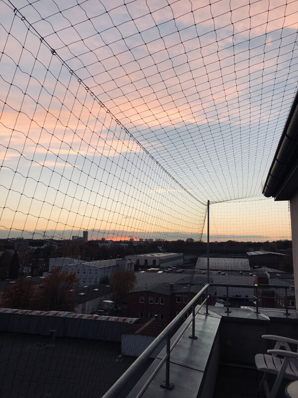 Balkon mit Taubenschutznetz vor Sonnenuntergang
